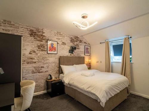a bedroom with a bed and a brick wall at City Comfort Rooms - Sheffield in Sheffield