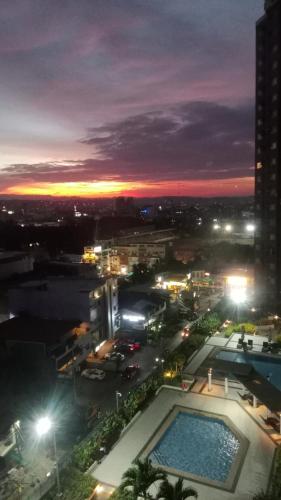 a view of a city at night with a pool at B4B Staycation Avida Aspira in Cagayan de Oro