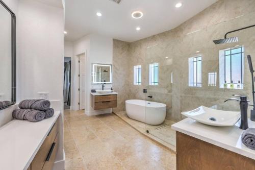 a large bathroom with a tub and a sink at CIELO - Modern Vegas Pool Oasis, Spa, Pickleball in Las Vegas