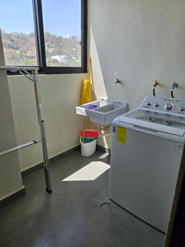 a bathroom with a sink and a washing machine at Departamento Huatulco 1 Torre Bel in Santa Cruz Huatulco