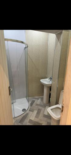 a bathroom with a shower and a toilet and a sink at The Coach House in Bradford