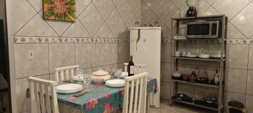 a kitchen with a table with chairs and a refrigerator at Happy GUEST House Beto Carrero in Navegantes