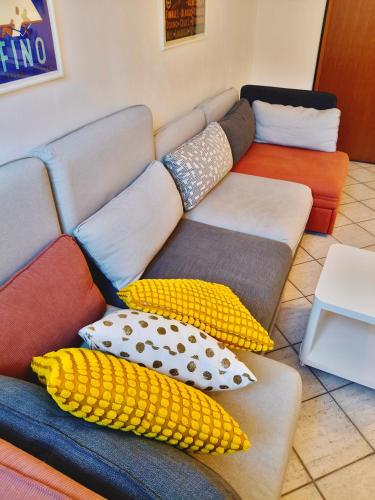a sectional couch with corn pillows on it at Old Town Apartment with Terrace - Live Love Lake in Peschiera del Garda