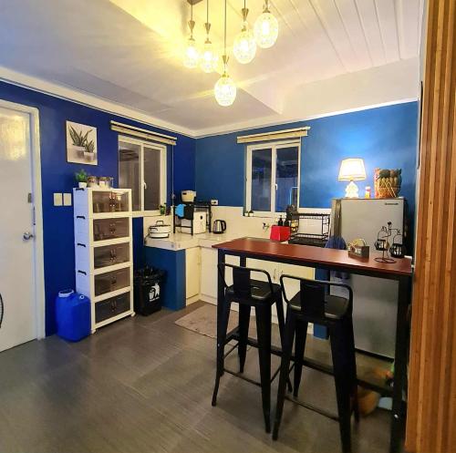 a kitchen with blue walls and a table and chairs at BCDCrib in Bacolod