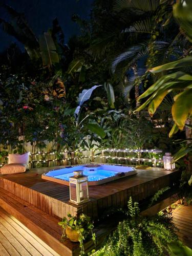 Ein Whirlpool auf einer Holzterrasse zwischen Bäumen in der Unterkunft Mini Casa com Jacuzzi e Piscina in Trancoso