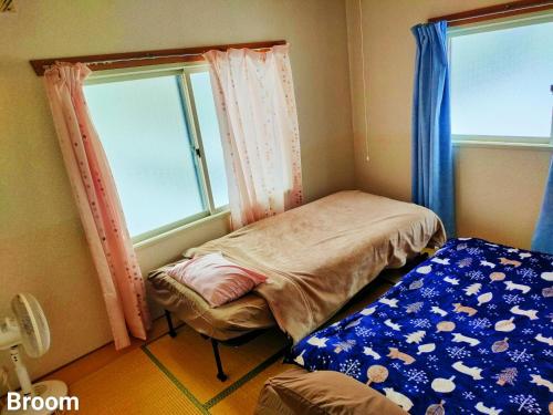 a small room with two beds and two windows at 别墅之家オーナーChangeAorB in Kami-furano