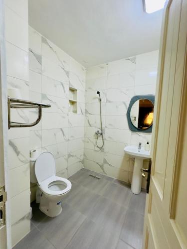 a white bathroom with a toilet and a sink at spacieuse vacation appartements in Essaouira