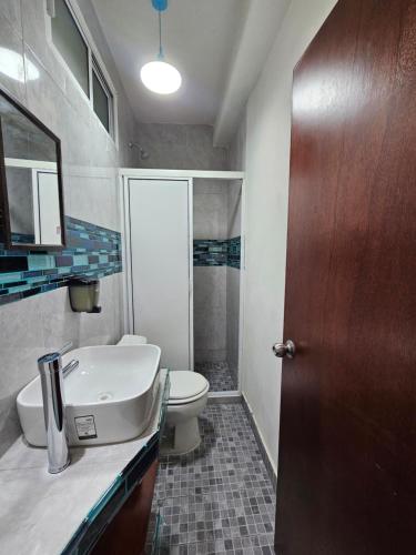 a bathroom with a white toilet and a sink at Departamento Turquesa in Barrio Nuevo