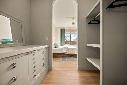 a bathroom with a dresser with a mirror and a bedroom at Villa Acadia with Mountain Views in Bar Harbor