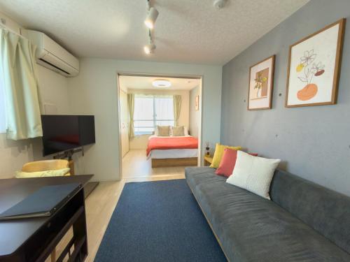 a living room with a couch and a television at Haneda apt area 15min by car Lovely New 1 bedroom 西糀谷501 in Tokyo