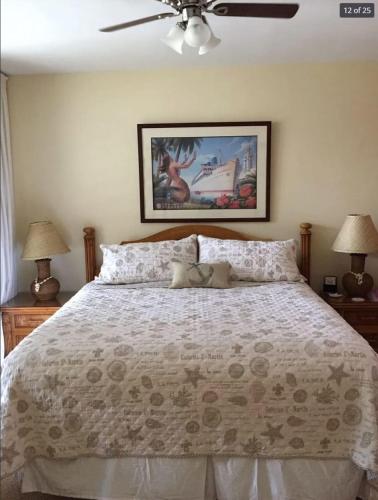 a bedroom with a bed with two lamps and a ceiling fan at Oceanfront with Private Beach! Hale Mahina Beach Resort A206 in Lahaina
