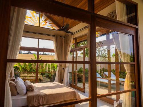 a bedroom with a bed and a large window at Villa Sun Soul - Brand New 2bed Villa w Rice Field View in Ubud