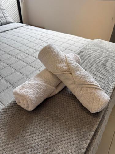 a stuffed animal is laying on a bed at Apartamento Moderno uma quadra do mar in Vila Velha