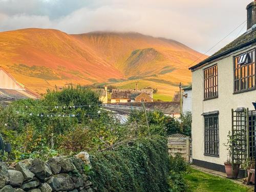 a village in the hills with mountains in the background at Jemima's Cottage in Bassenthwaite