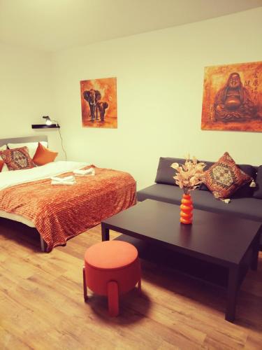 a bedroom with a bed and a table and a stool at Chillout Zone Neuss - Apartment mit Balkon in Neuss