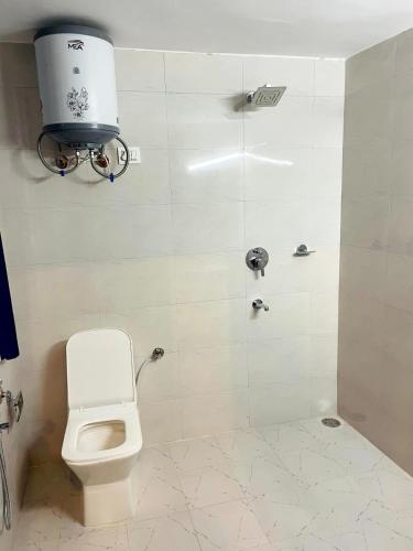 a bathroom with a toilet and a shower stall at Hideaway Tree House in Jibhi