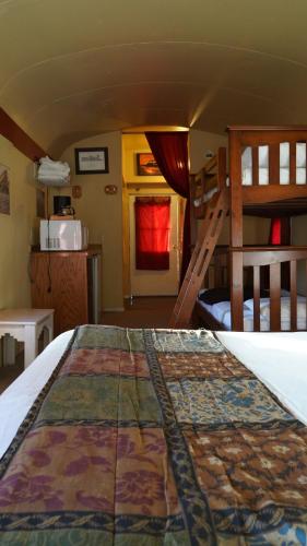 a bedroom with two bunk beds and a kitchen at Historic Rail car on route 66 in Williams