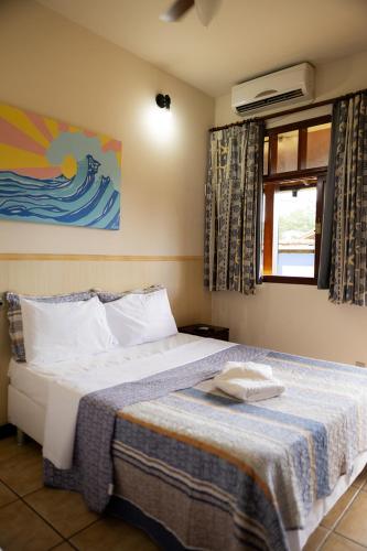 a bedroom with a bed and a window at Bella Pousada in Abraão