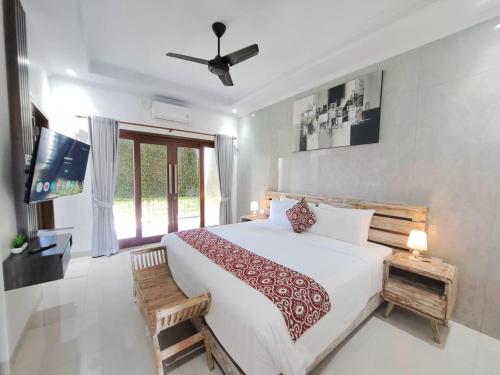 a bedroom with a large bed and a window at Paddy Villa Sanur in Sanur