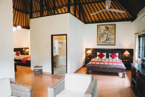 a bedroom with a bed and a living room at Liberty Dive Resort in Tulamben