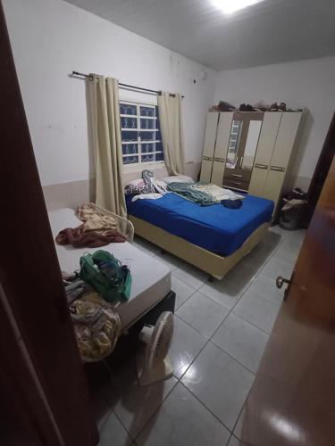 a small room with two beds and a window at Casa moto gp in Goiânia