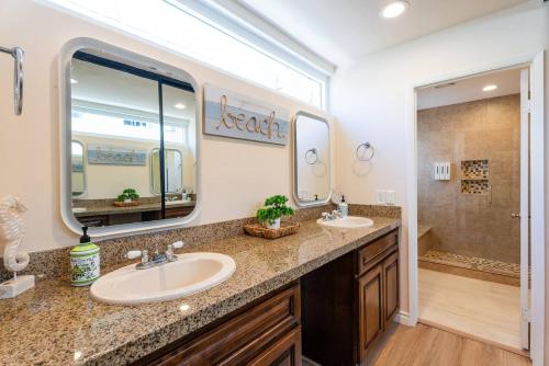 a bathroom with two sinks and a large mirror at Mission Casa Del Mar in San Diego