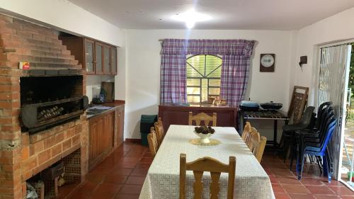 a kitchen and dining room with a table and a fireplace at Quinta Arce - Refugio Natural in Trinidad