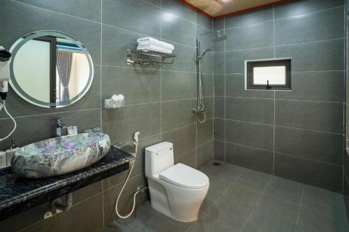 a bathroom with a toilet and a sink and a mirror at Trang An River View Ecolodge in Ninh Binh