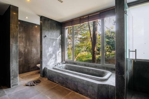 a bathroom with a bath tub and a window at V302 Exclusive Seaview 7BR Infinity Pool Villa in Por Bay