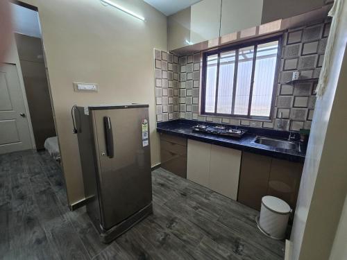 a kitchen with a stainless steel refrigerator and a sink at Sherans Cottage in Umargām