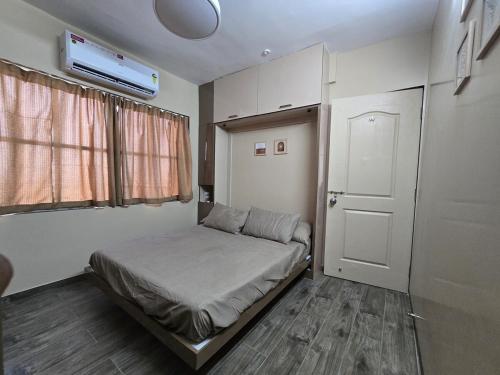 a small bedroom with a bed and a window at Sherans Cottage in Umargām