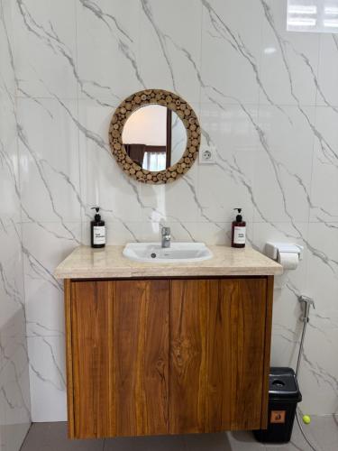 a bathroom with a sink and a mirror at Puri Lepang Riverside in Ketewel