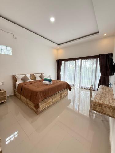 a bedroom with a bed and a large window at Puri Lepang Riverside in Ketewel