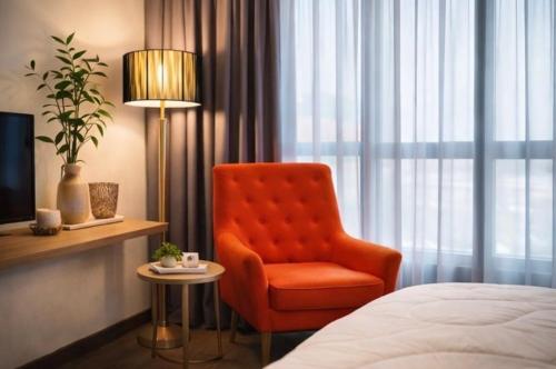 a room with a bed and a chair and a lamp at Tunjong Stay in Kota Bharu
