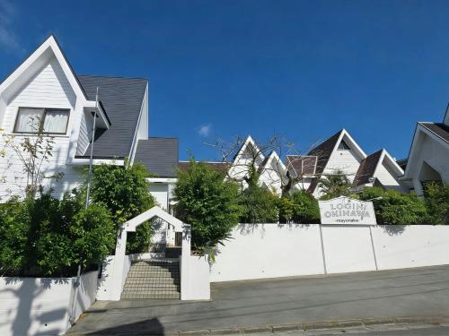 a row of houses behind a white fence at LOGIN OKINAWA -mayonaka- in Onna