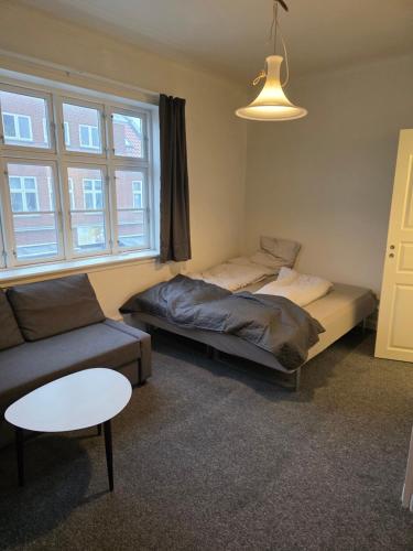 a room with two beds and a couch and a table at JP Apartment Floor 1 in Grindsted