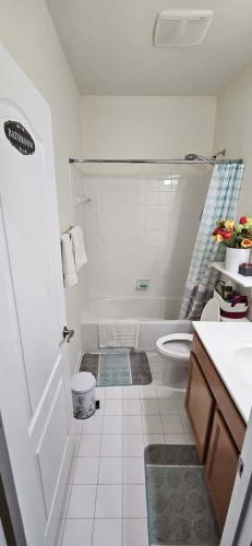 a white bathroom with a toilet and a sink at Single Room in Townhouse in Manassas