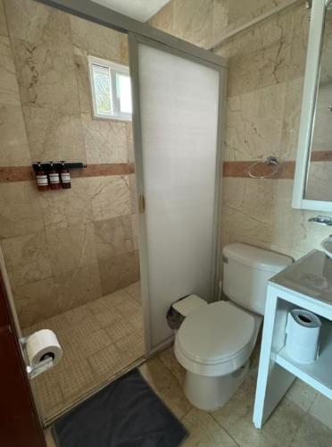 a bathroom with a toilet and a shower at Tropical Oasis with Pool Perfect Vacation Home in Puerto Morelos