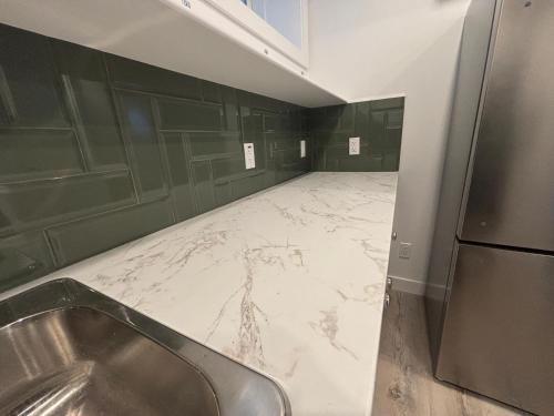 a kitchen with a marble floor and green walls at Hidden Gem in Airdrie