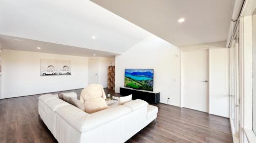 a white living room with a white couch at Lakefront 6B4B House by GoodLive in Patterson Lakes