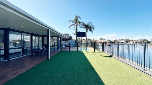 a balcony with a green lawn next to a building at Lakefront 6B4B House by GoodLive in Patterson Lakes