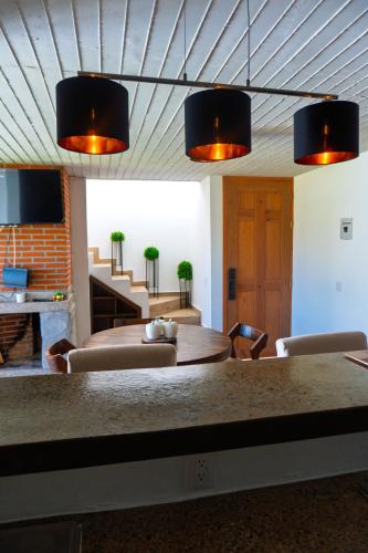 a dining room with a table and some lights at Montepinar Acosta Suites in Mazamitla