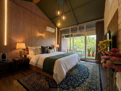 a bedroom with a large bed and a large window at Silver wings Kasauli in Kasauli