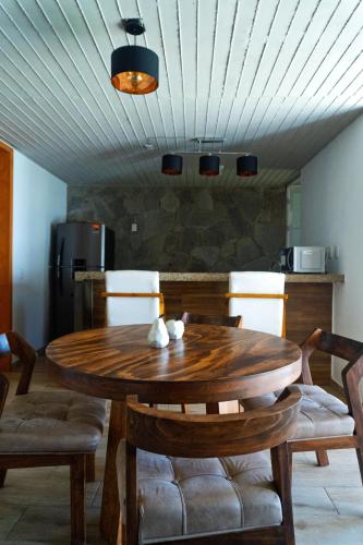 a wooden table and chairs in a room at Montepinar Acosta Suites in Mazamitla