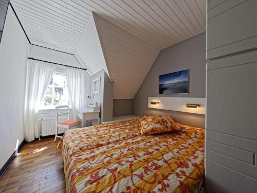 a bedroom with a bed and a desk in a room at Schroeders-Haus-Mitte in Kampen