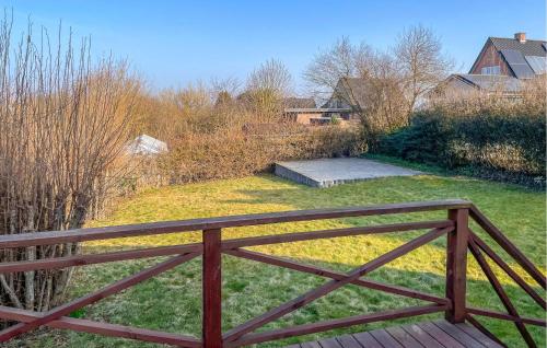 a wooden fence in front of a yard with grass at 2 Bedroom Awesome Home In Faaborg in Faaborg