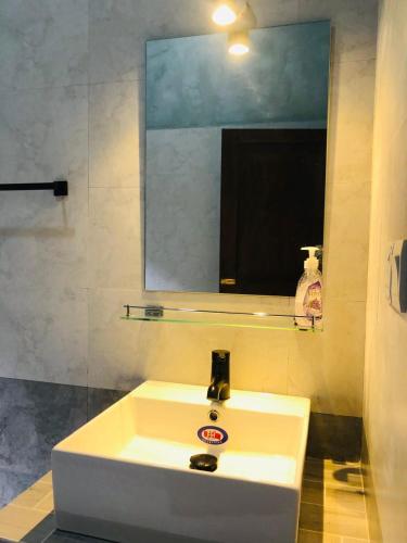 a bathroom with a white sink and a mirror at Unawatuna Backpacker Lodge in Unawatuna