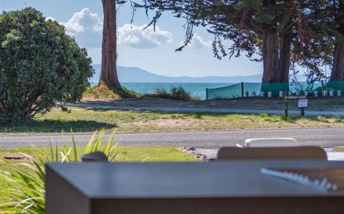 a view of a road with trees and the ocean at Pohara's Beachside Bliss in Pohara
