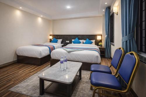 a hotel room with two beds and a table and chairs at Funky Monkey Hostel Hotel & Apartment Thamel in Kathmandu