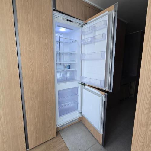 an empty refrigerator with its door open in a room at 원스테이 가산디지털단지 in Seoul